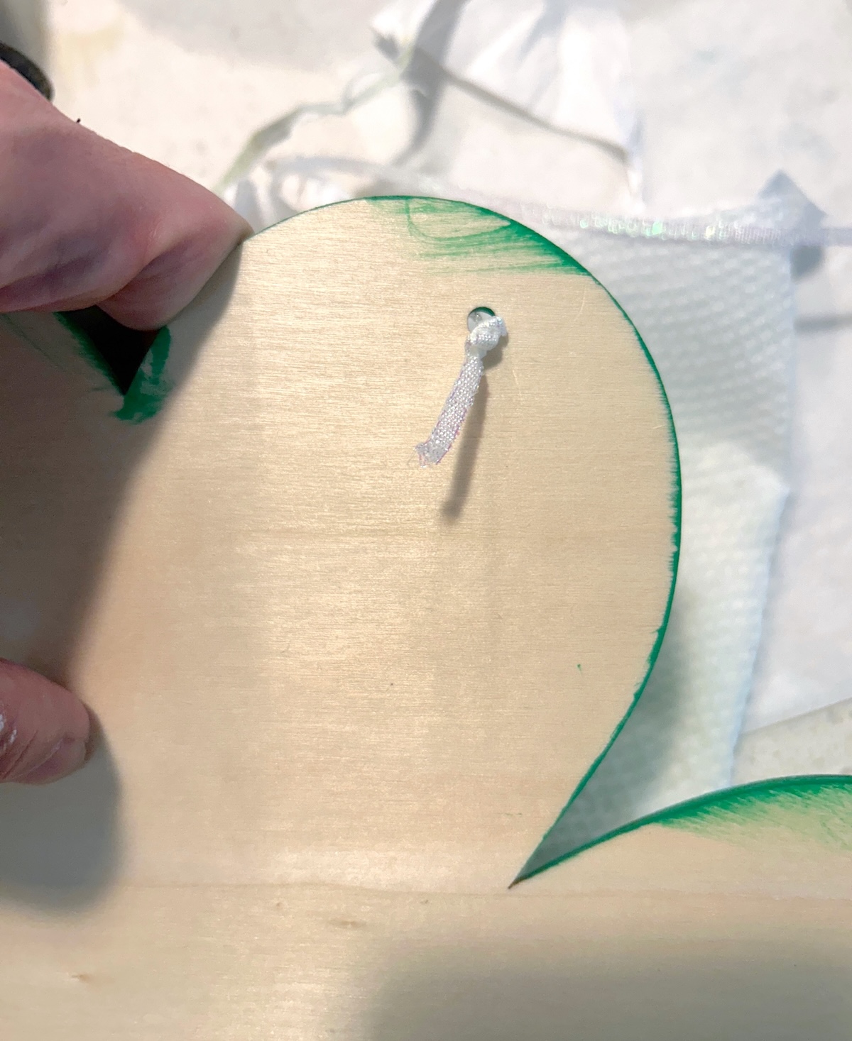 Adding white ribbon to the shamrock to hang